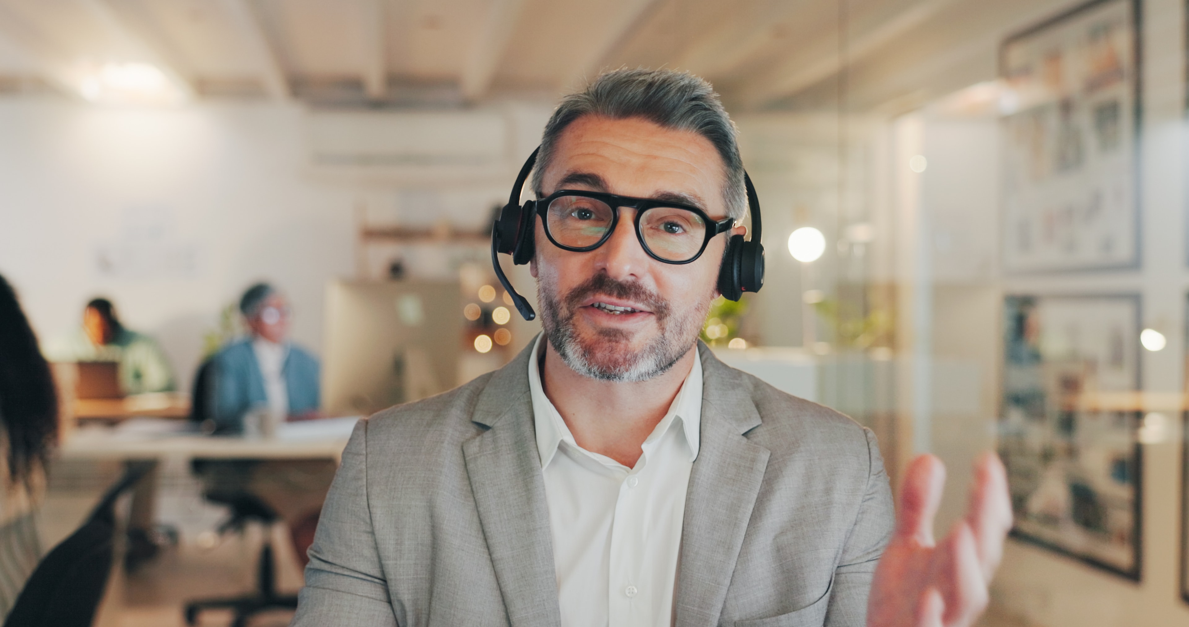 Professional on a video call with headset in a modern office